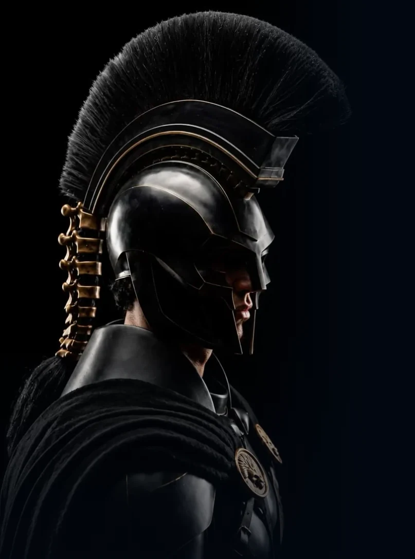 Sentinela de perfil com elmo negro e detalhes dourados diante de fundo azul-escuro.